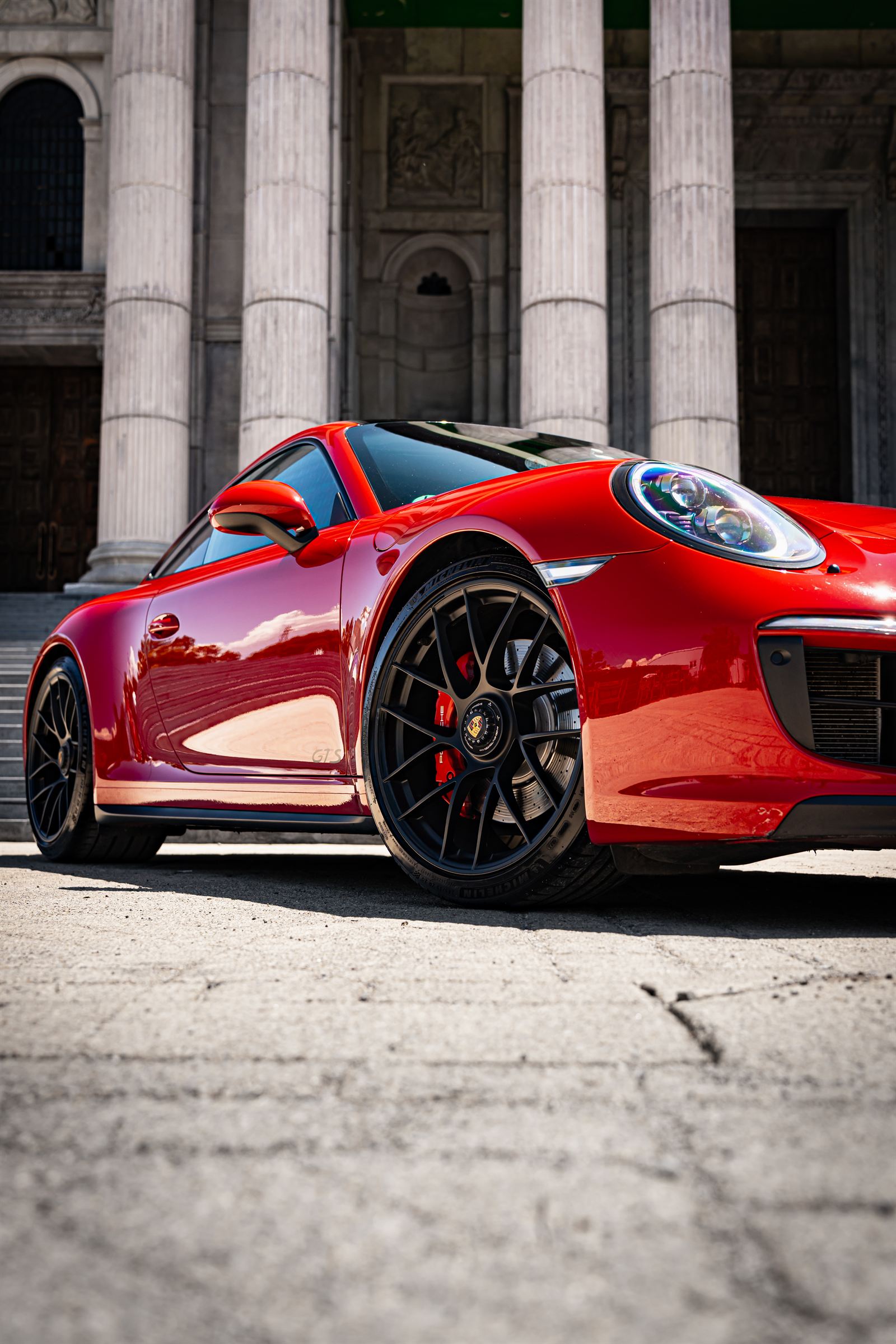 Червено Porsche 911 пред колоните